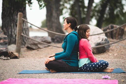 Mother and daughter sitting back to back